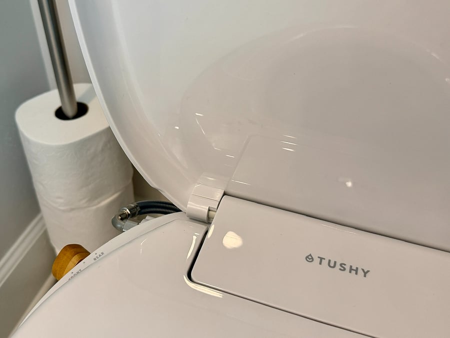 Toilet comes equipped with a Tushy bidet seat for personal hygiene.