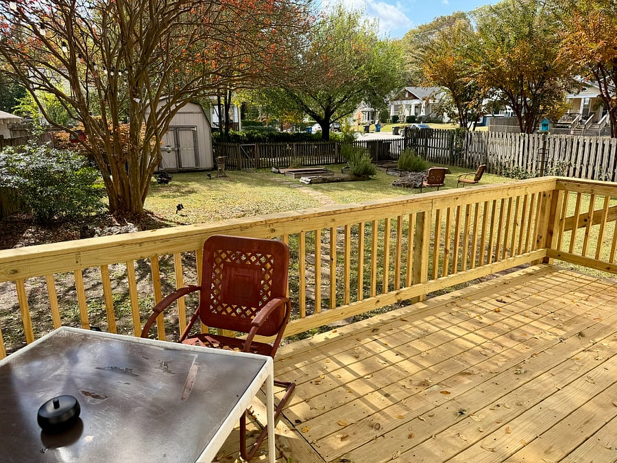 View of backyard from deck. Ashtray included on table.