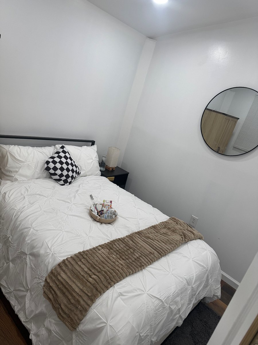 Bedroom with plush bedding, night stand, and armoire for clothing storage