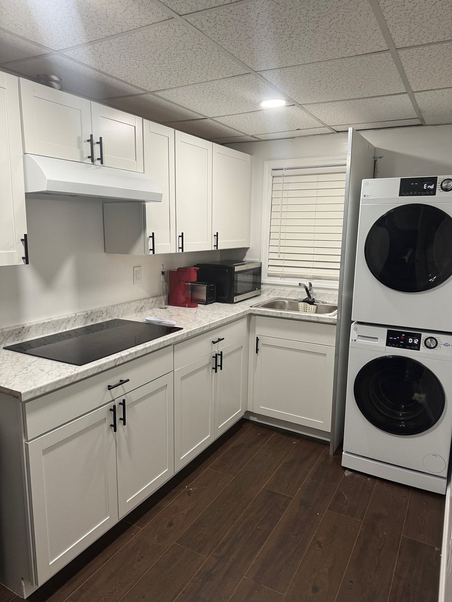 Fully stocked kitchen with modern cabinetry, appliances, cookware and dinnerware
