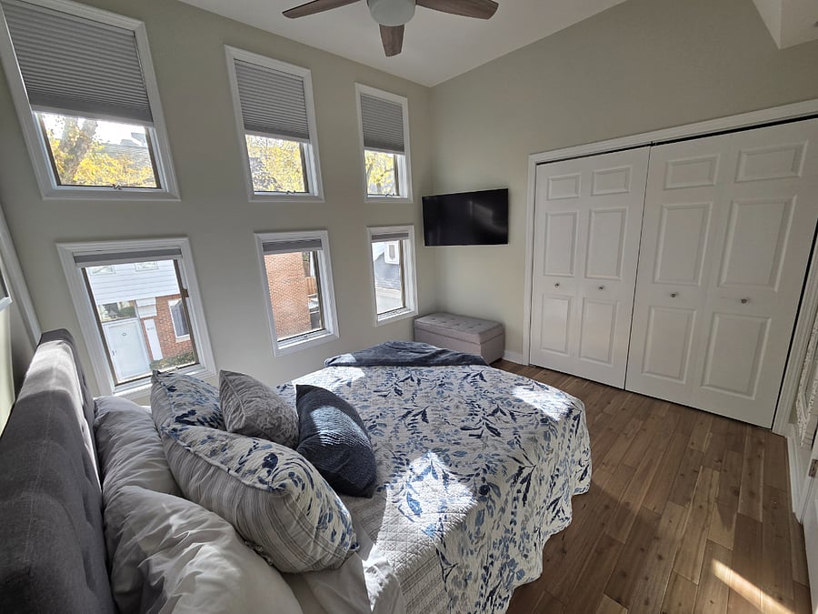 Bedroom has mounted TV and 2 closets