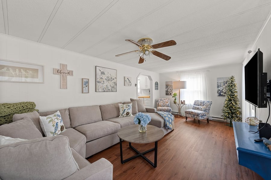 Large living and seating area with large flat screen TV and celing fan