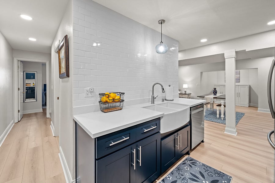 New kitchen with farmhouse sink and wall of white subway tile.
