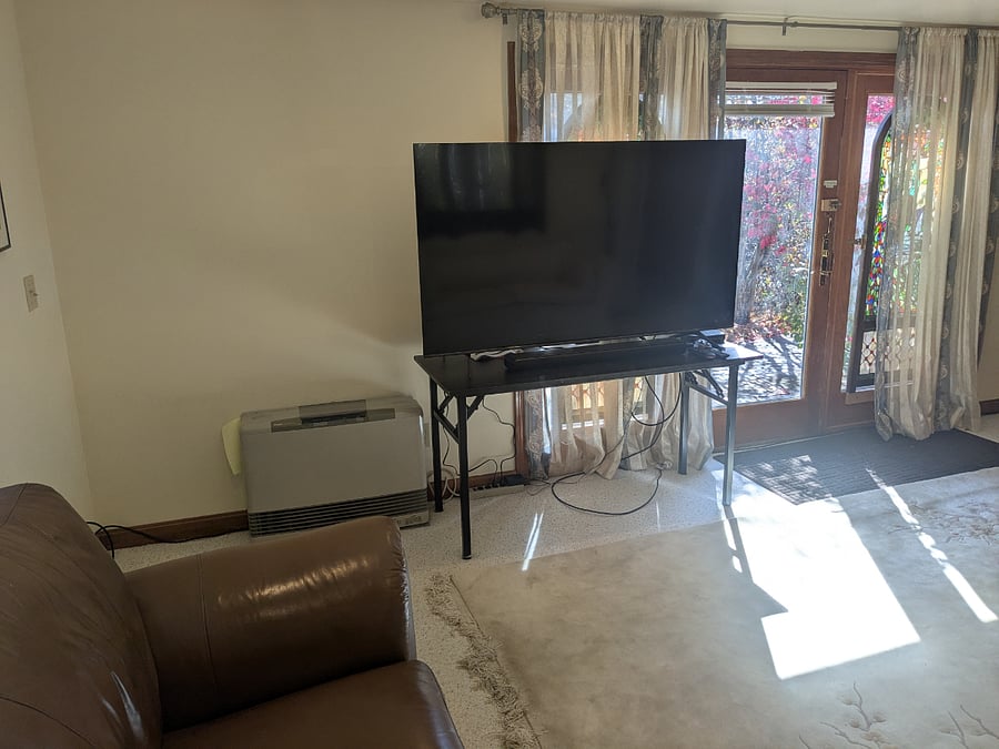 Living room -third view - New Smart 65 inch TV - Dish network included in rental. Patio doors behind TV lead to bluestone patio in photo above