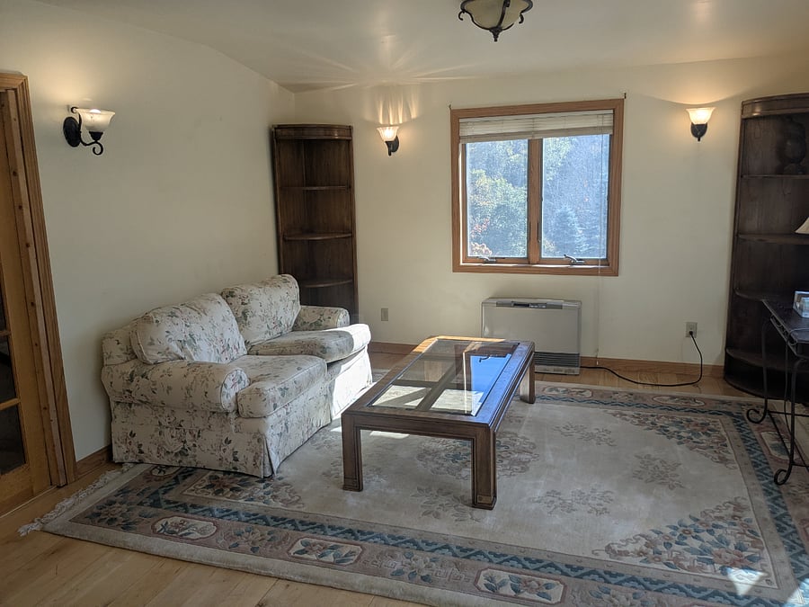 Upstairs bedroom. Very large room with sitting area on one side. Next photo is the opposite end of this room with comfortable Queen bed.This bedroom has sliding door and private deck outside. This room measures13x25 This room also has a minisplit unit above a slider that leads to a private deck - see photo to the right.