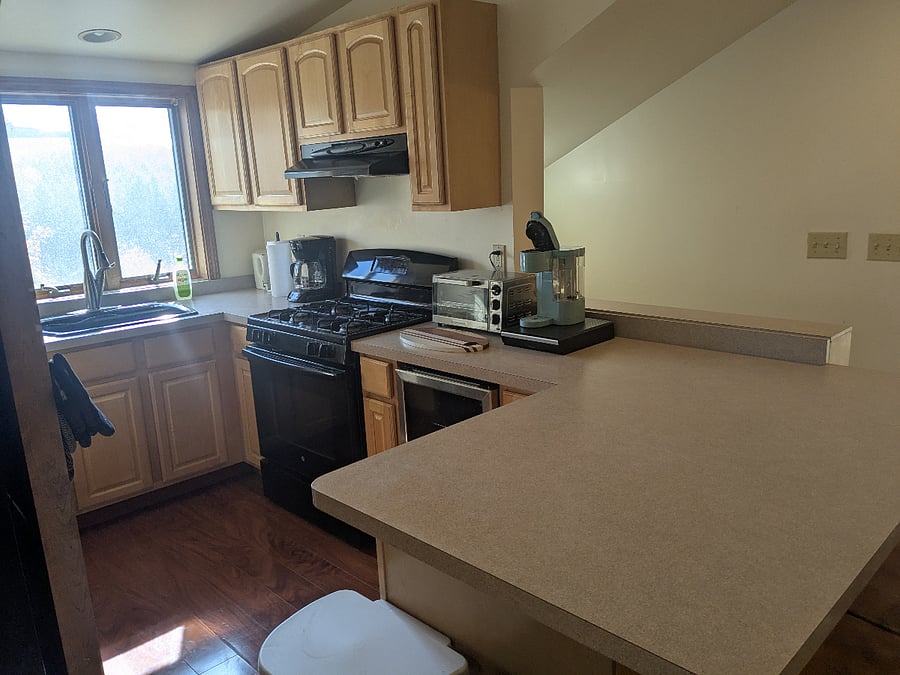 Kitchen. Nice views of front of property. Kitchen fully stocked (dishes, cooking utensils, pots and pans) Dishwasher, second beverage fridge under counter.Microwave and toastroven. Counter with additional seating for two. Landlord will provide condiments and other essentials if he is provided a list by prospective tenant.