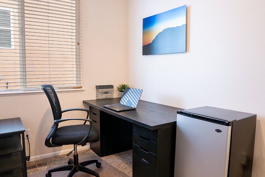 2nd available bedroom with a large desk and a mini fridge. Laptop is not included.