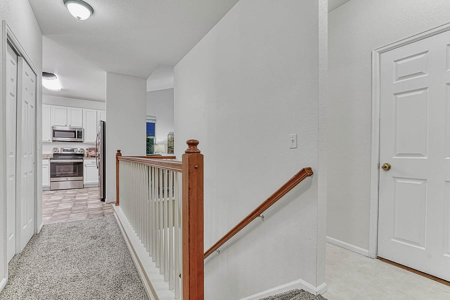 View down the hallway to the kitchen and living room. The spaces are divided, giving the feel of privacy. Fron