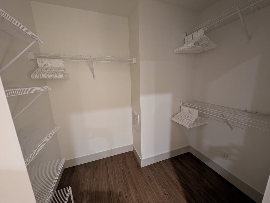 Large, walkin bedroom closet with hangers provided
