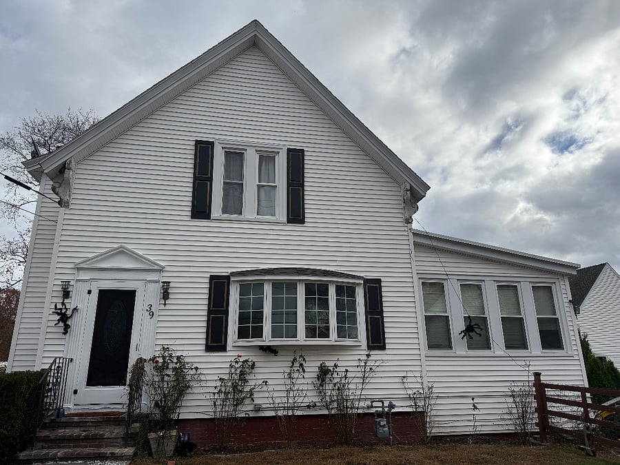 Two story colonial home in quiet neighborhood. Front yard has BBQ grill and small deck area with chaise loungers and high top table for relaxing outdoors during summer/fall months.