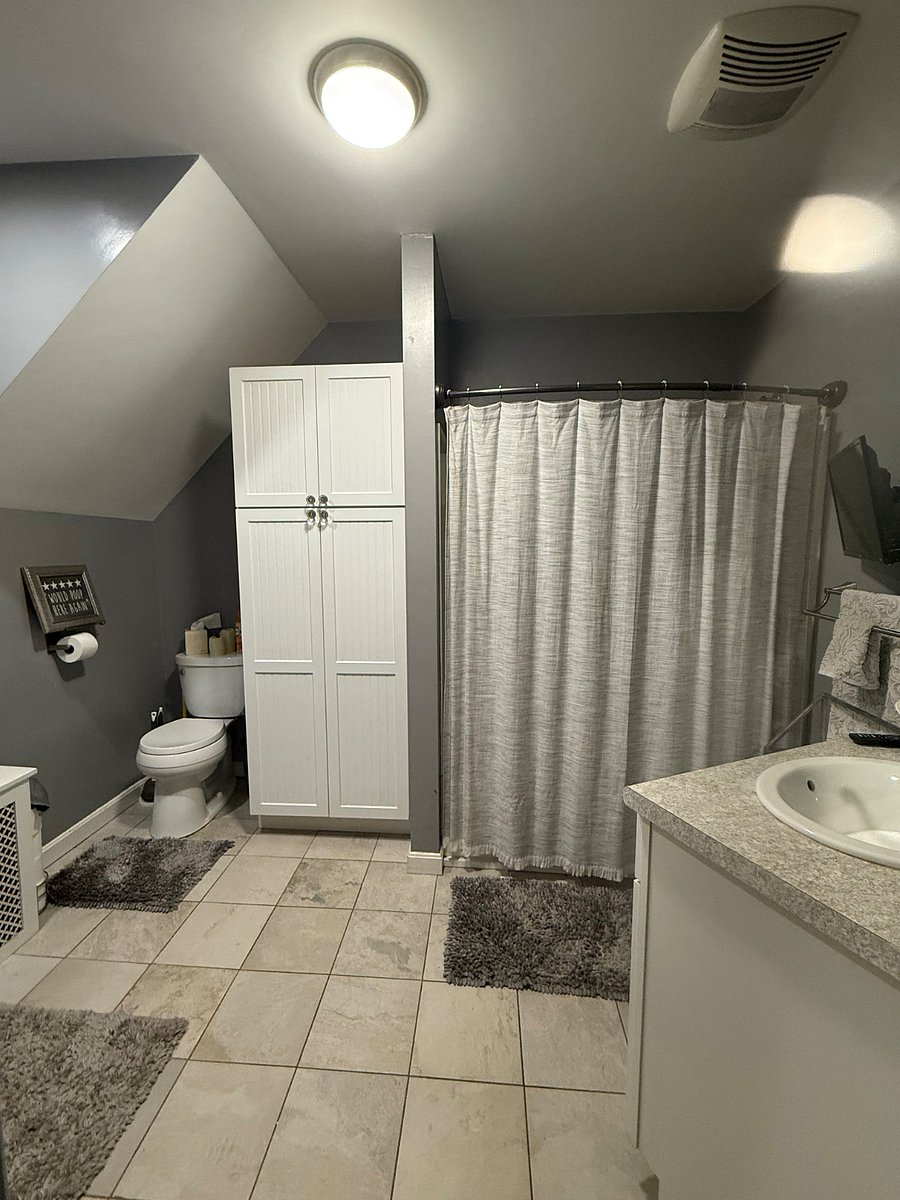 Spacious, shared bathroom with shower/tub combination, two vanities and mirrors.
