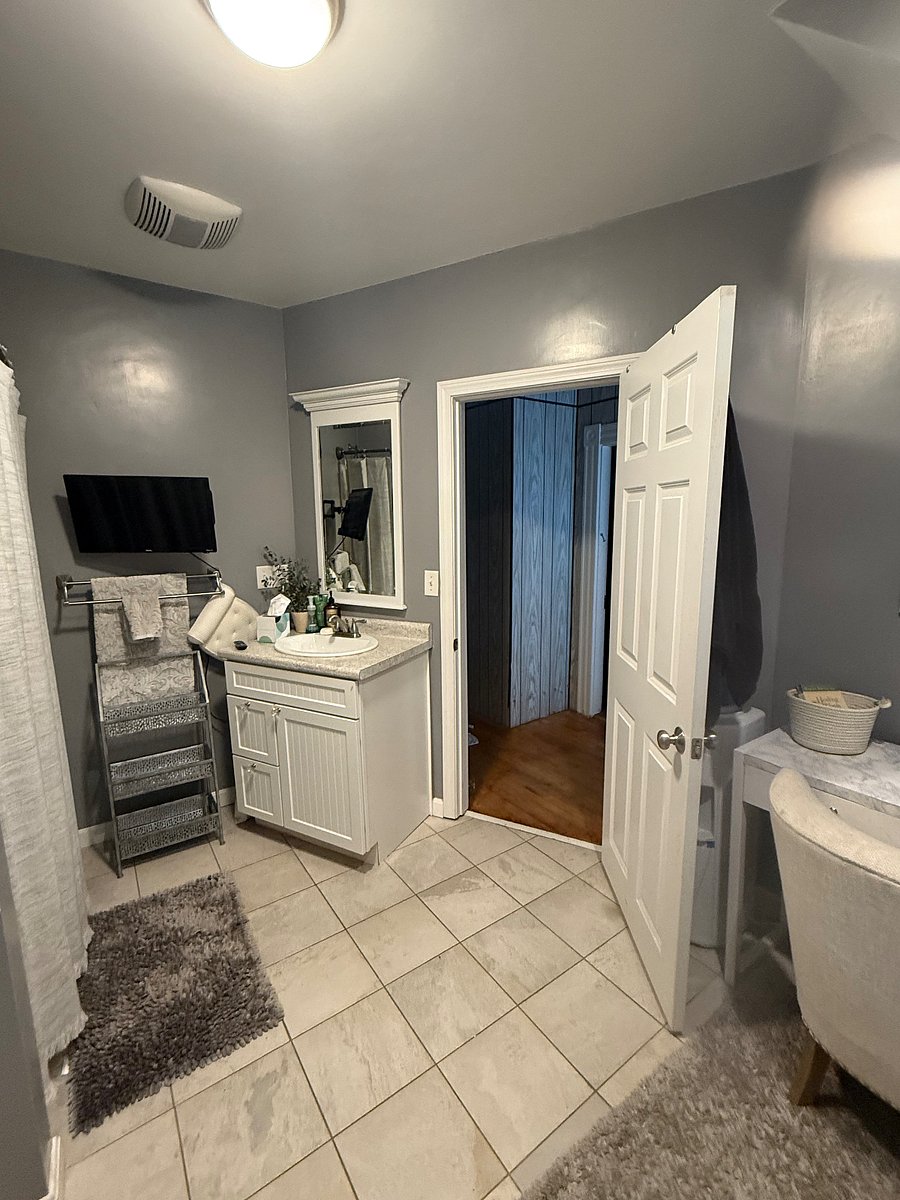 Spacious, shared bathroom with shower/tub combination, two vanities and mirrors.