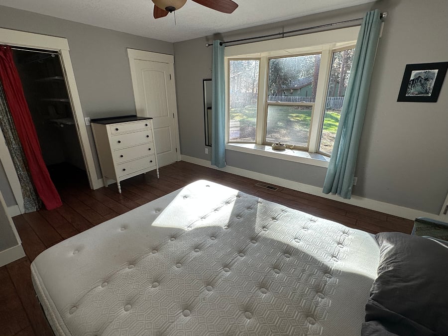 Master bedroom w/ bay windows. Door left of the windows is the master bathroom. Curtains on the left lead to the closet.