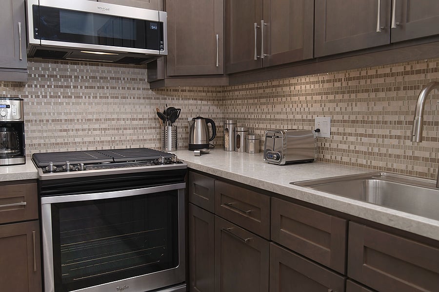 Full kitchen details, with an above the stovetop microwave with venting, coffee maker, electric tea pot and utensils