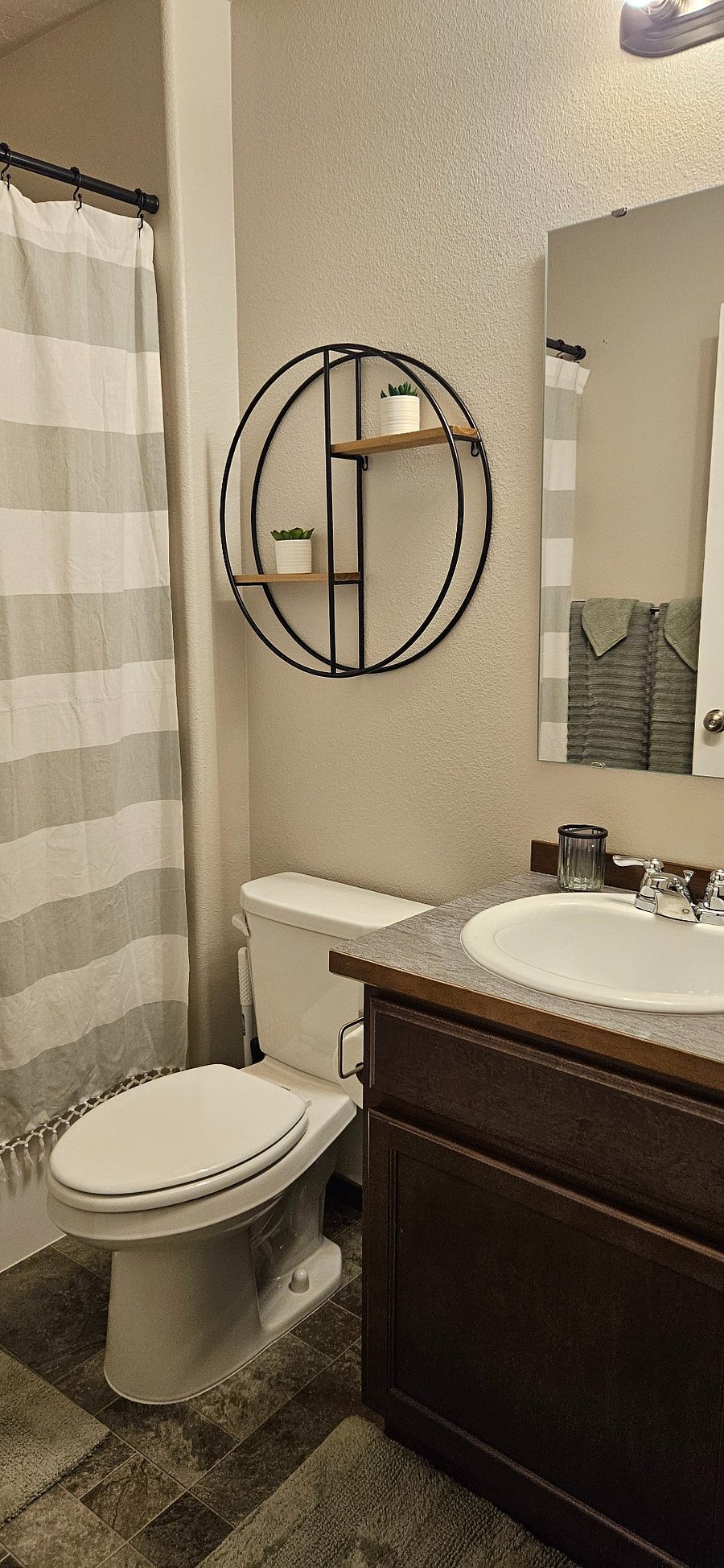 Full size bathroom with single vanity sink, stand up shower with tub, all soaps and toilet paper provided