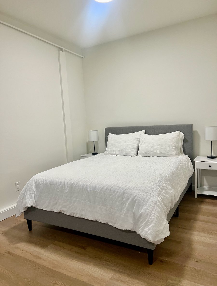 Queen bed with side tables and quality linens.