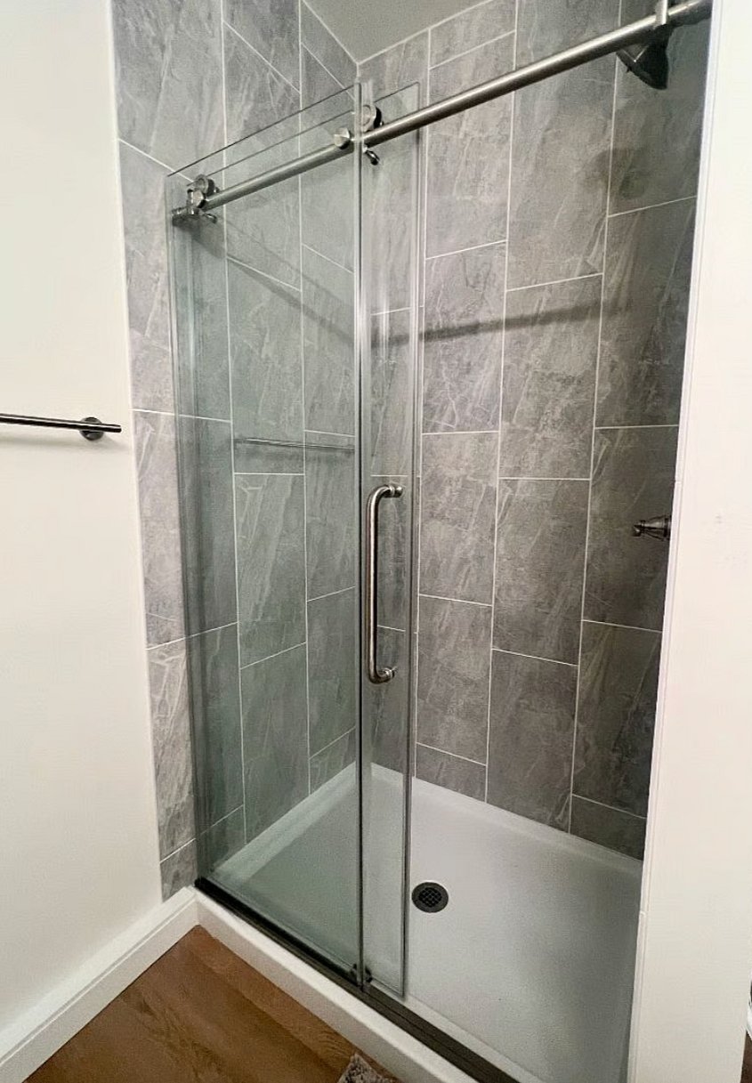 Luxurious tiled shower with glass sliding door.