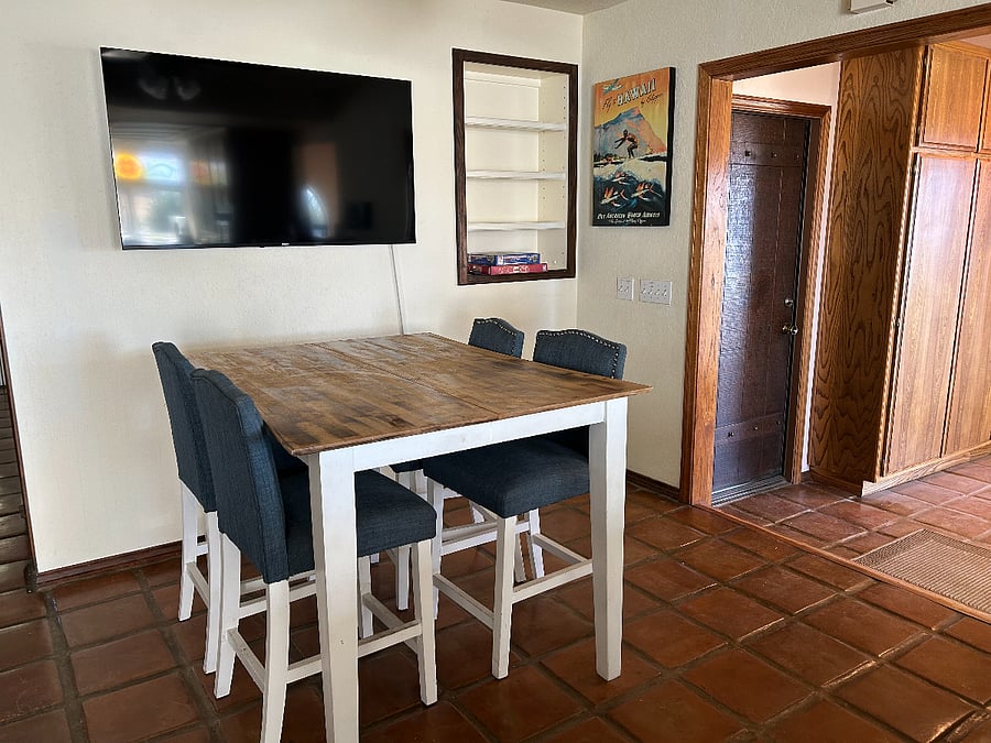 Large TV with bar table for four in the kitchen area. Enoy the game!