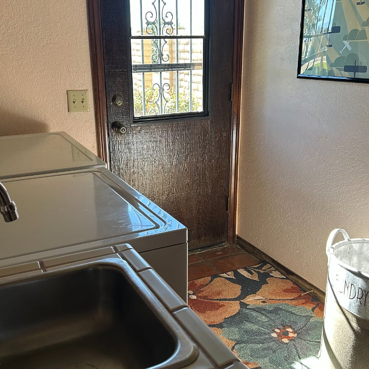 Laundry room with sink and door to outside.