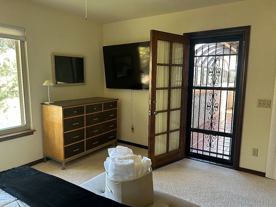 Bedroom #3 has an entrance to the upstairs solarium,  The door is curtained to provide privacy.
