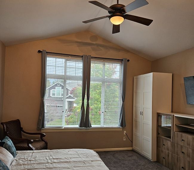 Vaulted ceiling with ceiling fan and light. Room also has 4 track lights.