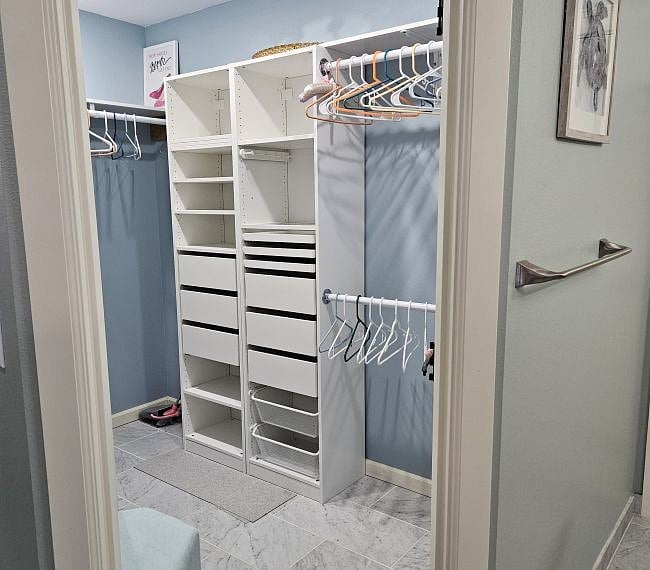 Huge walk-in closet in the mast bathroom with lots of built-in storage shelves and drawers.