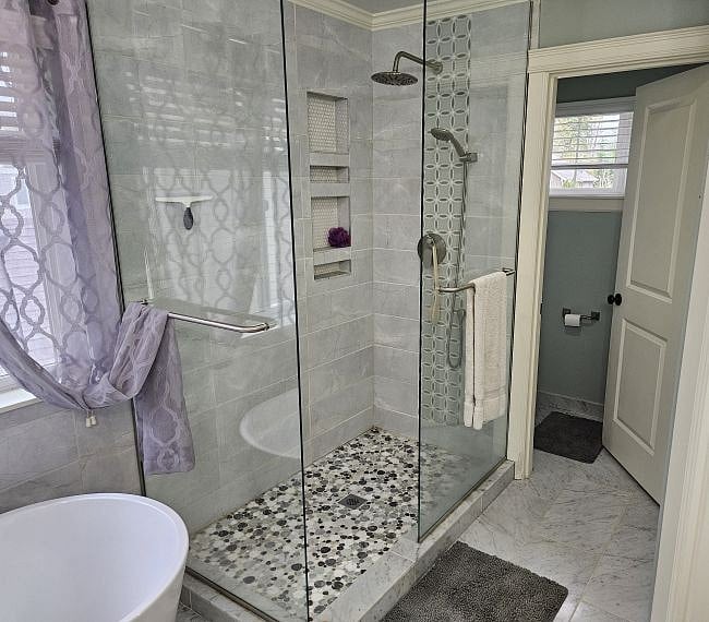 Adjacent to the deep tub is a large walk-in shower with rain showerhead plus hand-held showerhead.  there is a private enclosed commode.