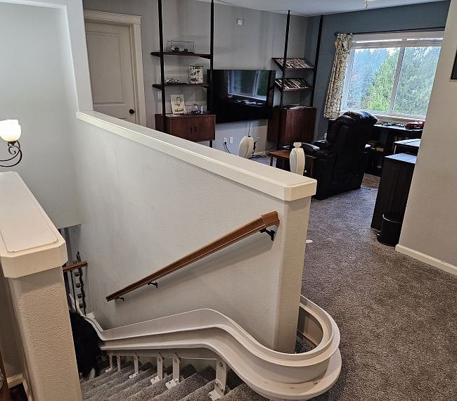 To the right of the stairway is the loft with reclining chair and 65-in LG QLED Smart TV with Roku.