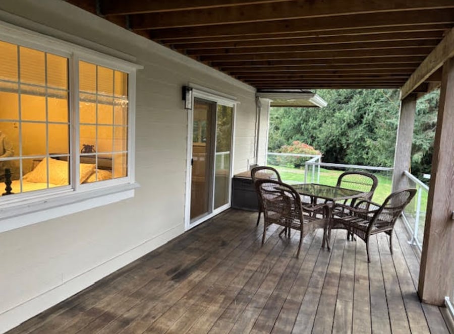 Private outdoor deck with seating off the living room.