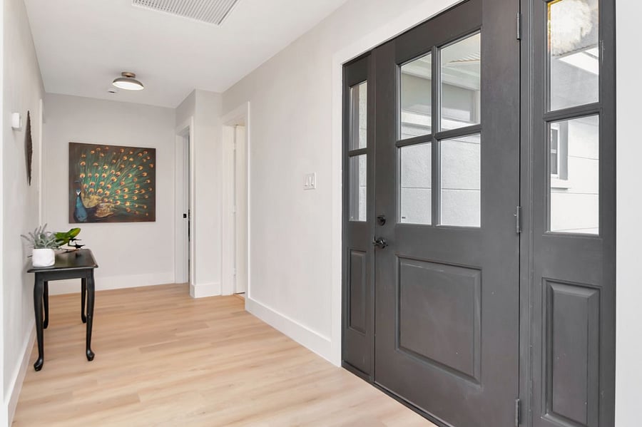 The two bedrooms are located to the right of the front door near the peacock painting.
