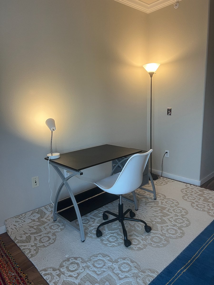 Office space with desk and rolling adjustable height chair.