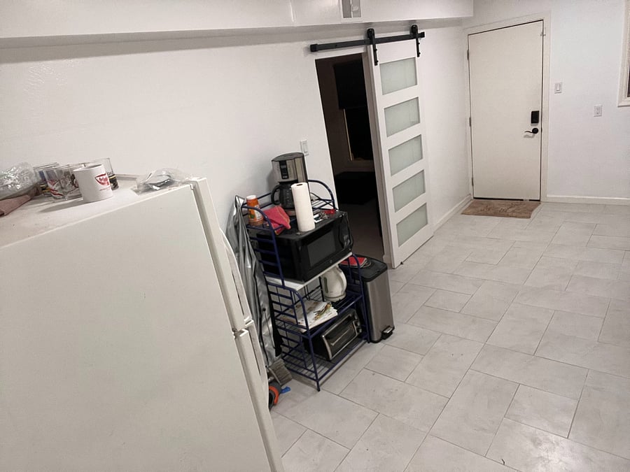 view from end of kitchenette (in progress) toward Ground Level Unit entry door and farm door to living room. 