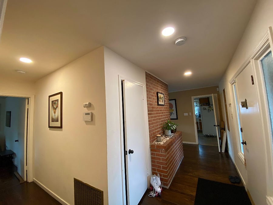 front door opens to the brick entry. 
view of hallway to kitchen, dining and living rooms to the front view and the bedrooms and bathrooms are behind camera view and down left hallway. 