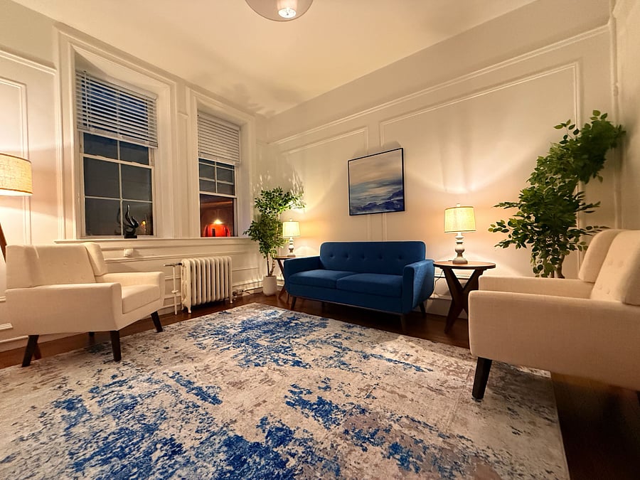 Inviting living area featuring a bold blue sofa, accent seating, and classic design details.