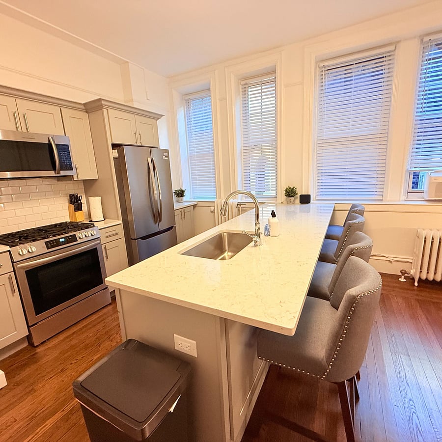 modern kitchen featuring high-end stainless steel appliances, a generous island with bar seating, and beautiful hardwood floors