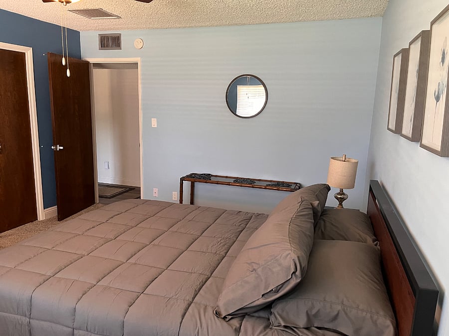 Middle bedroom, large and comfortable with queen bed plus a table and two chairs.