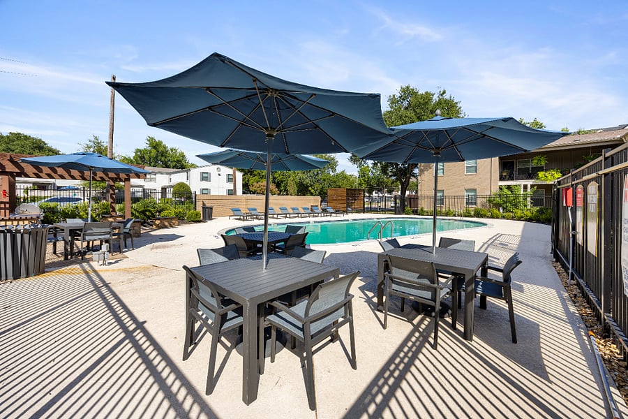 Community pool with loungers and sun shades.