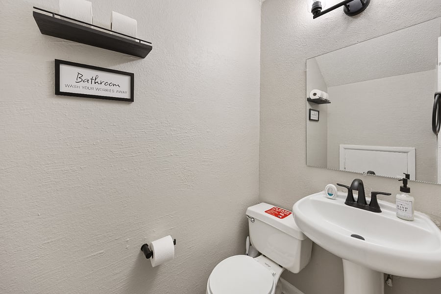 Half bathroom with toilet, sink, and misc. bathroom essentials.