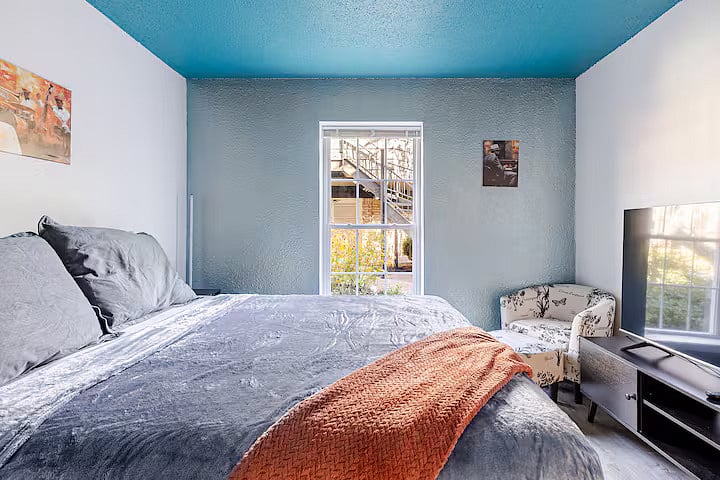 2nd bedroom with natural light, smart TV, and workspace.