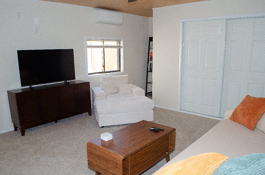 Living area with day bed, lounge chair, and Samsung smart tv. Mini split for head and ac.
