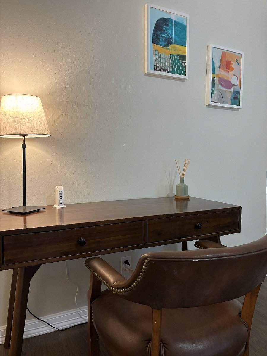 Dedicated working space in living room with charging station for multiple devices.