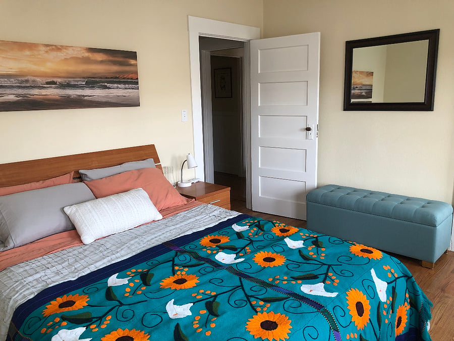 Comfortable Queen bed with extra bedding stored in the bedside bench