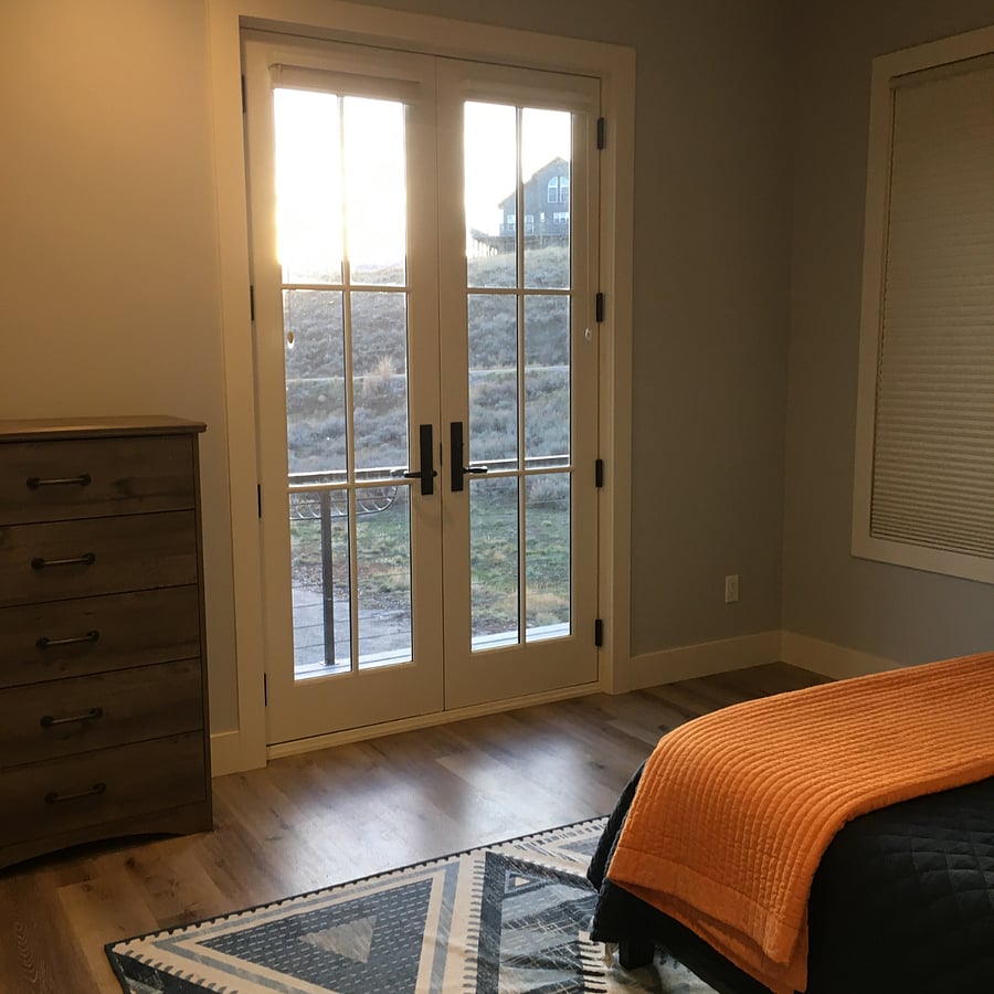 Bedroom 2, large French doors lead out to west facing deck. 