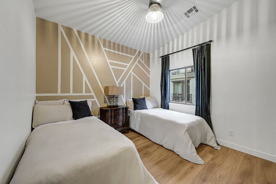 Guest room with two XL twin beds and dedicated workstation with monitors and printer.