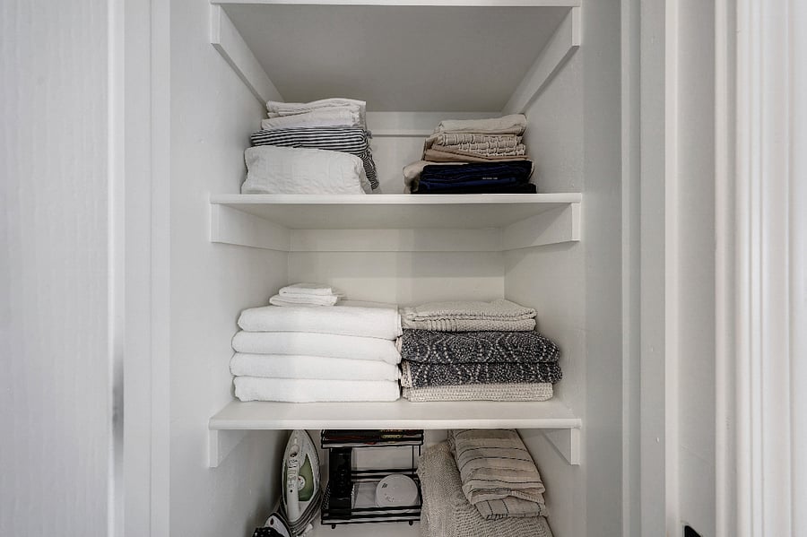Linen closet stocked with towels, sheets, and other essentials.