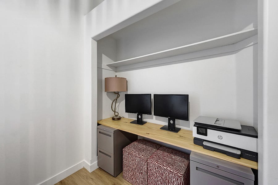 Workstation equipped with dual monitors, a printer, and filing cabinets for your office needs.