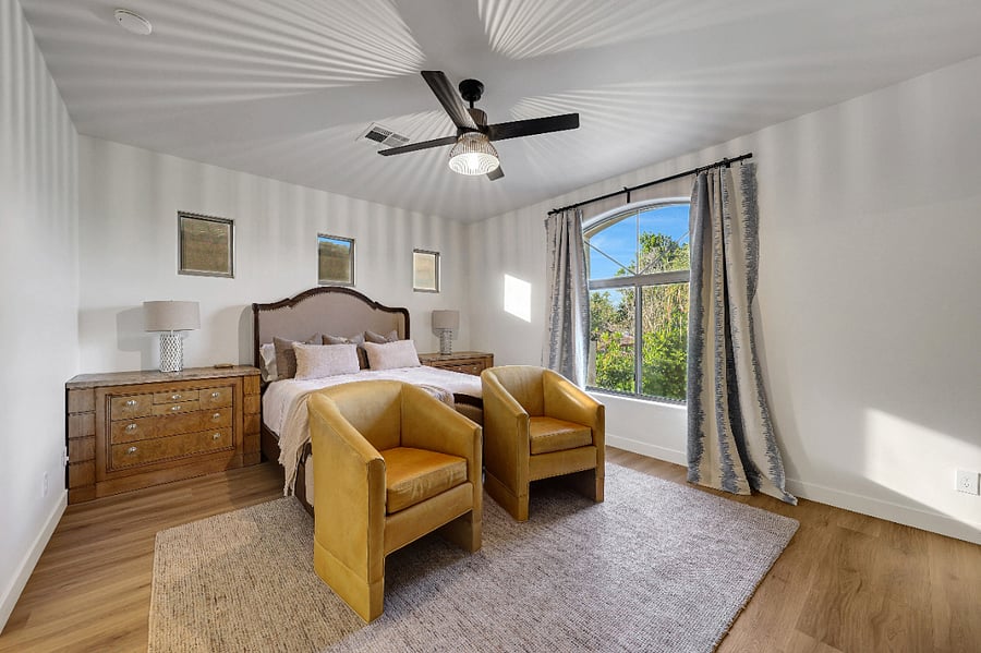 Primary bedroom includes a queen bed, cozy sitting area, and TV for your convenience.