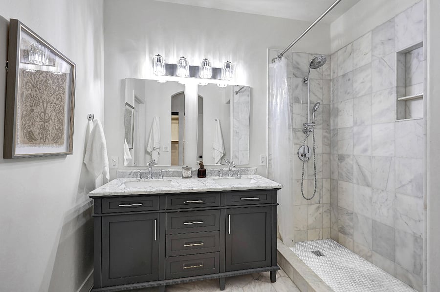 Primary bathroom features marble finishes, a separate toilet room, and a walk-in shower.