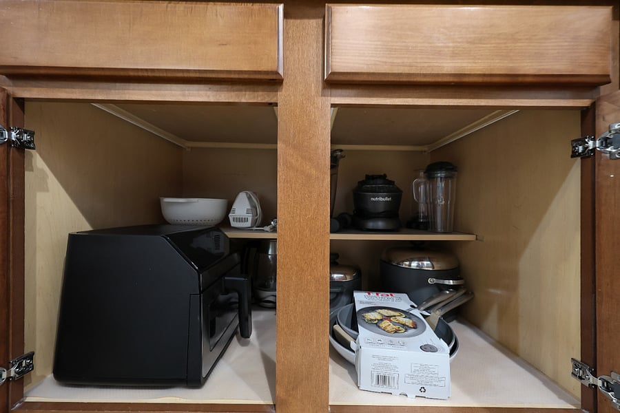 Kitchen fully stocked with pots, pans, and appliances like NutriBullet and air fryer.