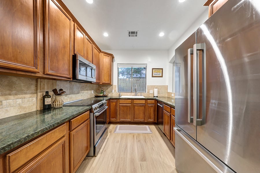 Bright kitchen with all appliances: fridge, stove, microwave and dishwasher.